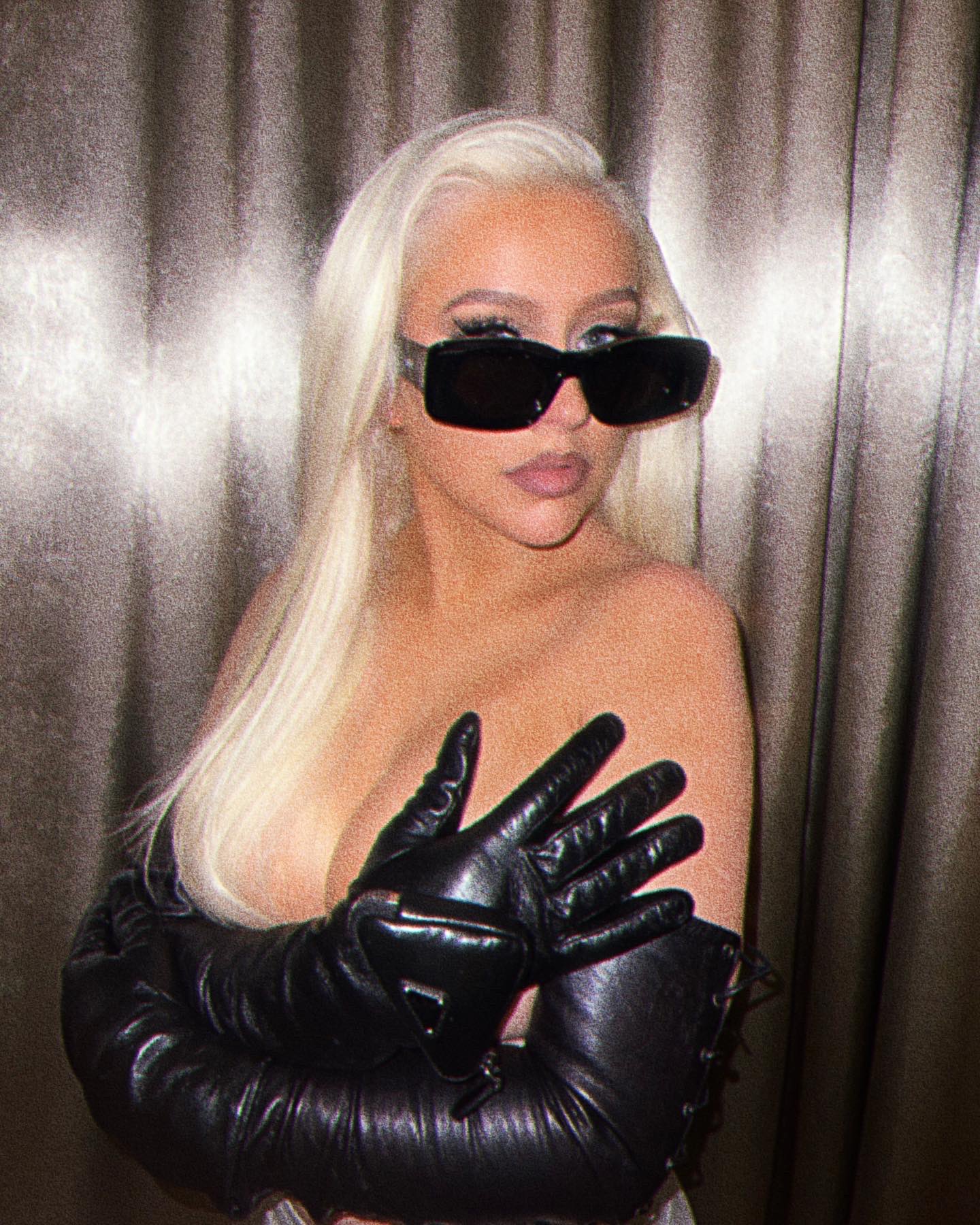 In addition to sporting black eyeglasses, Christina Aguilera is sporting black leather arm warmers. She is also posing without a top. In the pictures, Christina is using her hands and occasionally her hair to conceal the front section. Singer's message is currently receiving a fantastic response from his admirers.